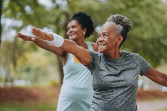 Two women stretching outdoors, embracing active wellness